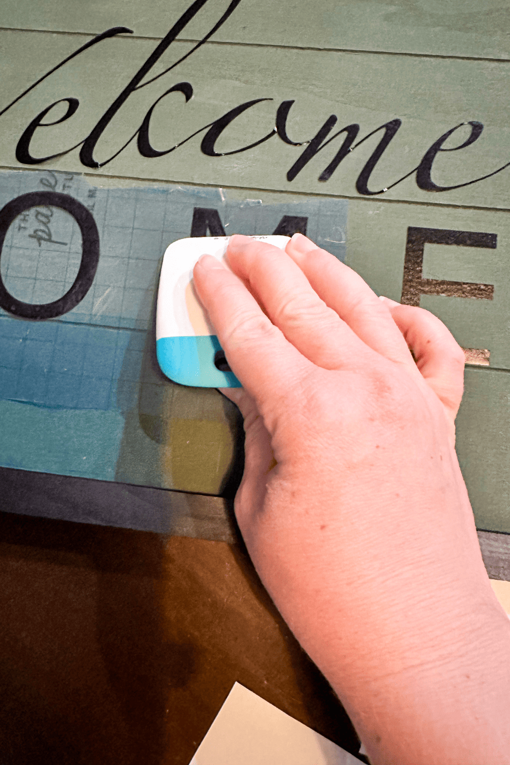 Showing a close up of rubbing the M with a cricut tool 