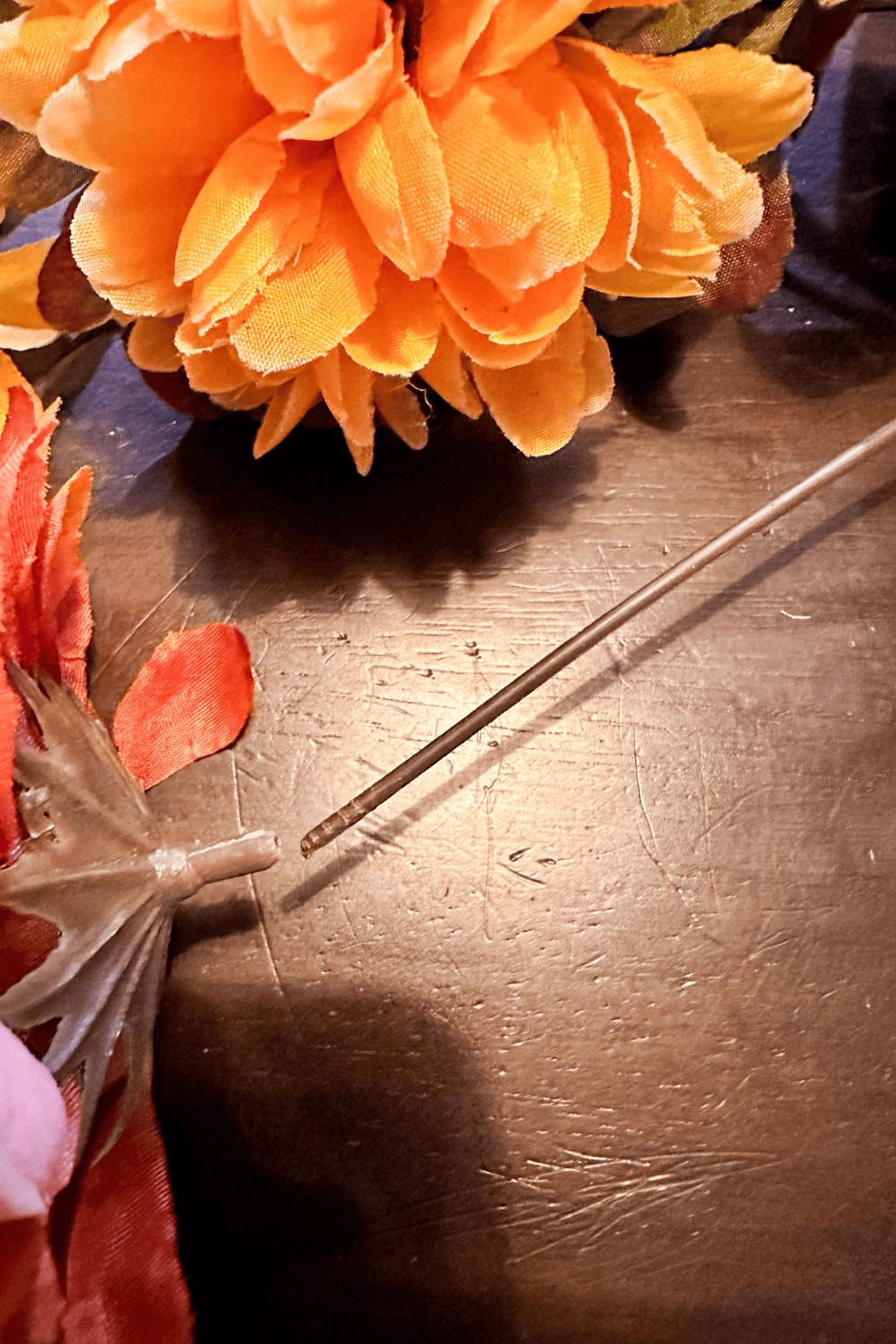 Showing a close up of popping a fake flower top off of a stem