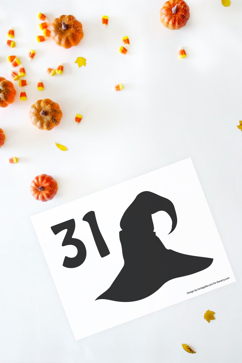 Preview of witch hat with number 31 silhouette pumpkin stencil printable on white background with little pumpkins and candy corn decorative items in upper left corner.
