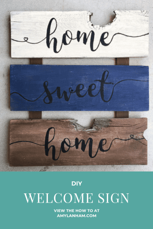 Wooden sign that says home sweet home in black vinyl and sign is painted white, blue, and brown