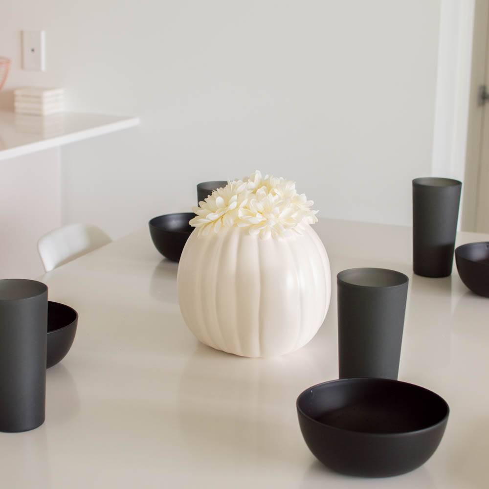 White pumpkin decor as a centerpiece of a long white table