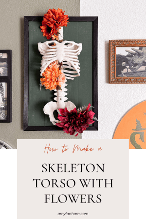 skeleton torso with red and orange flowers attached to a green board
