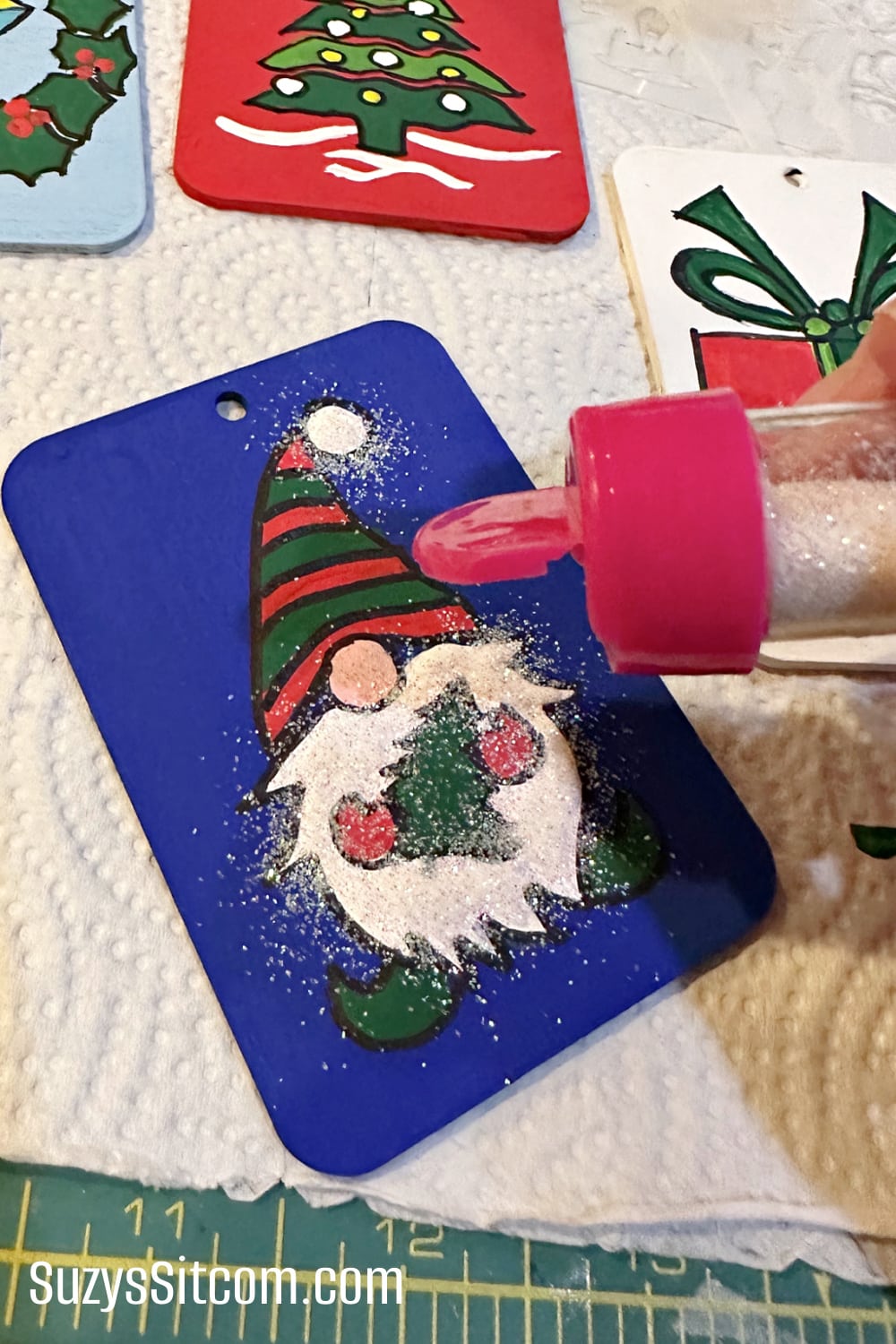 Adding glitter to the wooden gift tags.