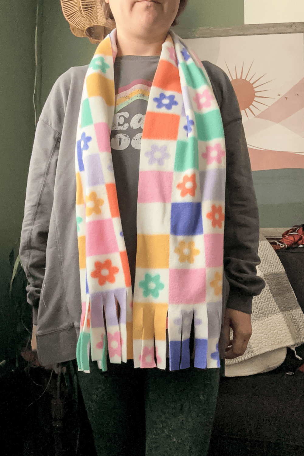 woman wearing a colorful pastel and white scarf with squares and flowers.