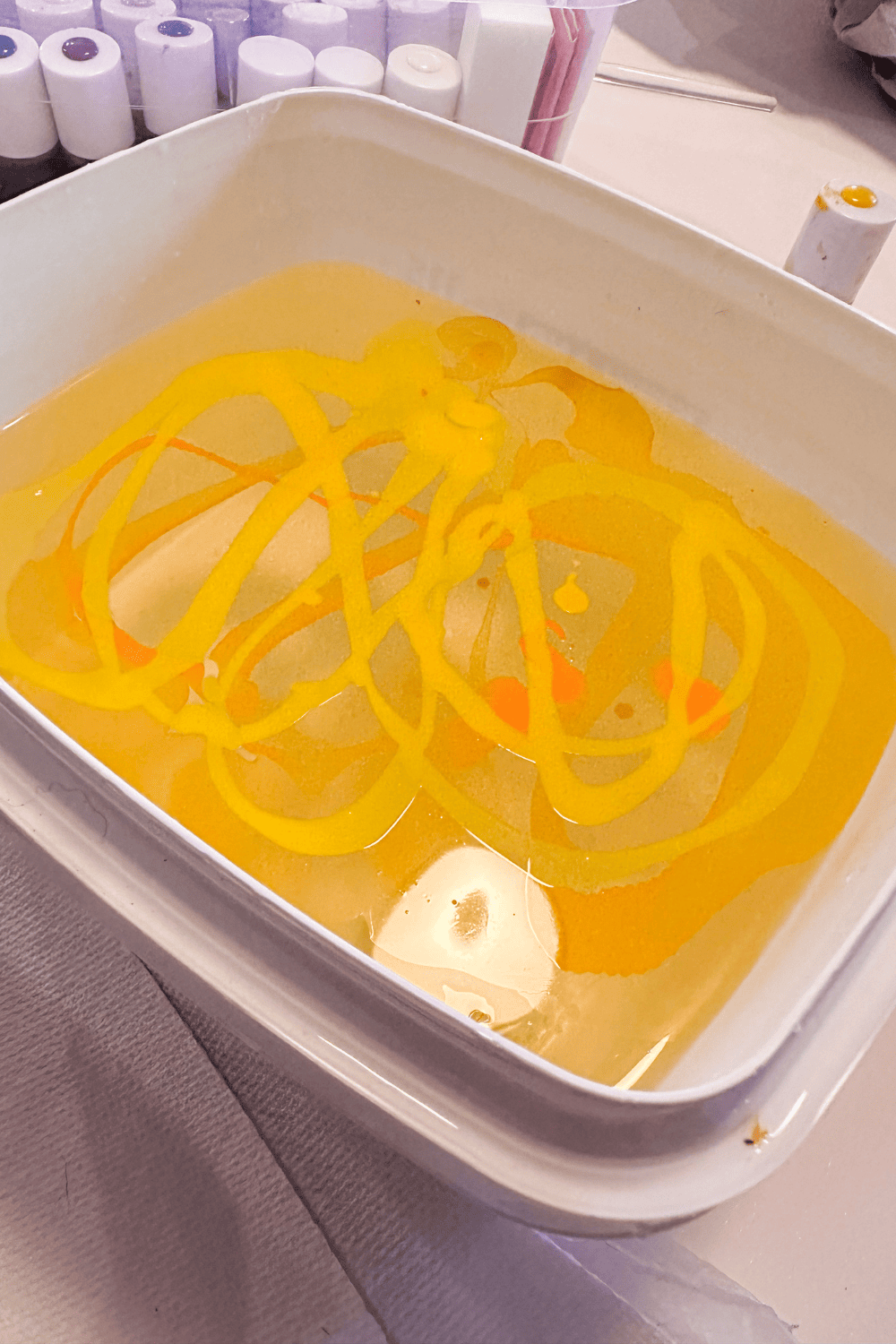 yellow and orange nail polish floating on water