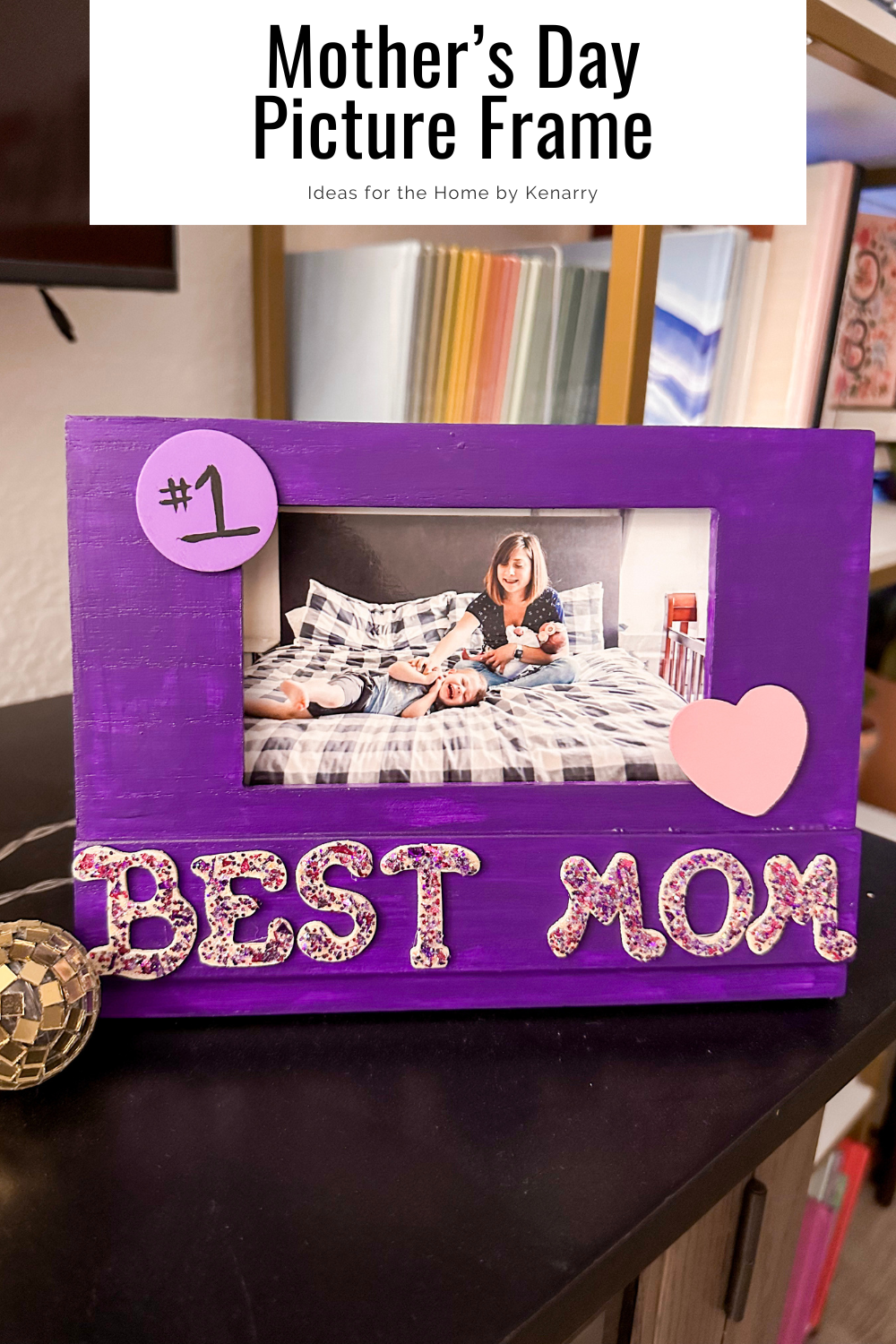 Purple picture frame that has best Mom in glitter letters. A picture is inside of a mother sitting with her two children.