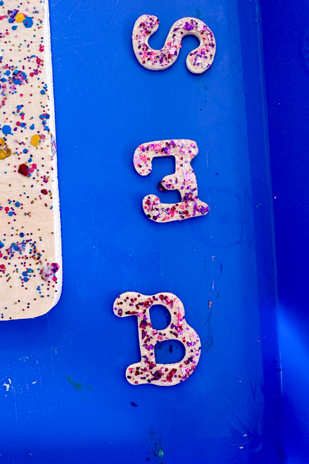 Close up of the wood letters painted with glitter paint.