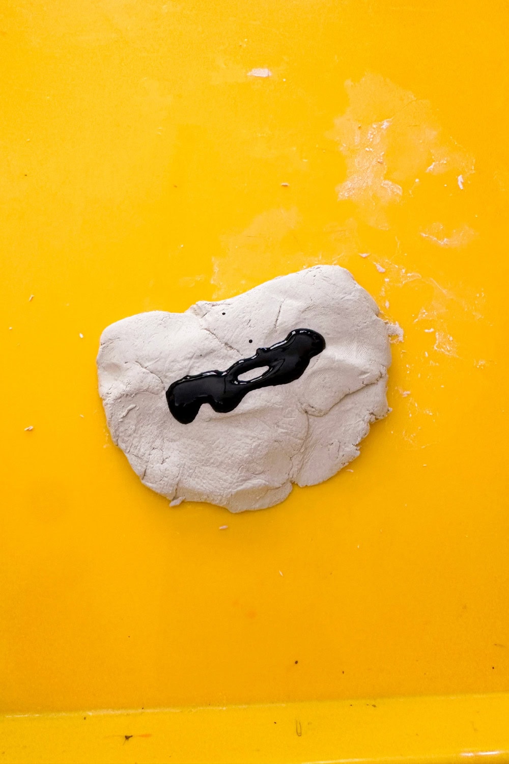 A squirt of black paint on off white clay
